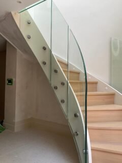 A curved glass balustrade follows the line of this split-level staircase, fixed with discrete stainless steel standoffs for a clean, floating effect. Every panel was custom curved to match the exact sweep of the stair, creating a seamless transition between floors. A subtle but highly technical detail that sets the tone for the entire interior. #CurvedGlass #ArchitecturalGlazing #GlassBalustrade #StaircaseDesign #BespokeInteriors #HighEndResidential